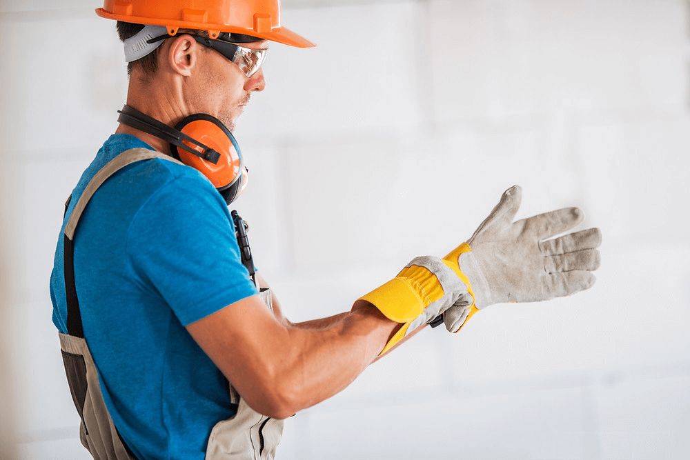 Técnico de segurança do trabalho vestindo luvas de proteção.