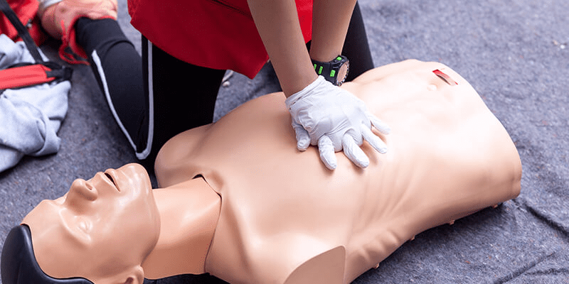 Instrutor simulando uma massagem cardíaca de primeiros socorros.